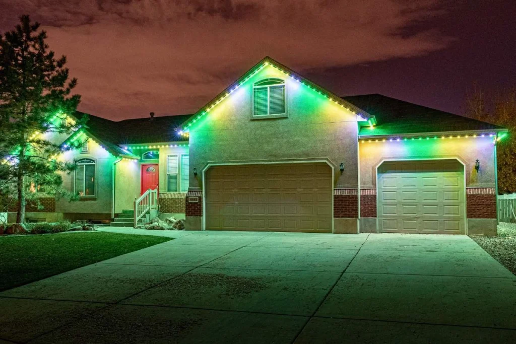 A house is decorated with colorful Christmas lights under a night sky