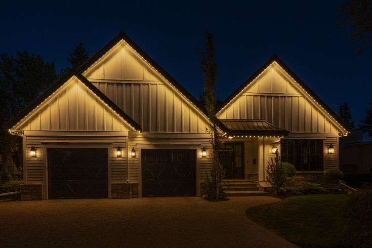 A beautifully illuminated modern house glows softly against a dark evening sky
