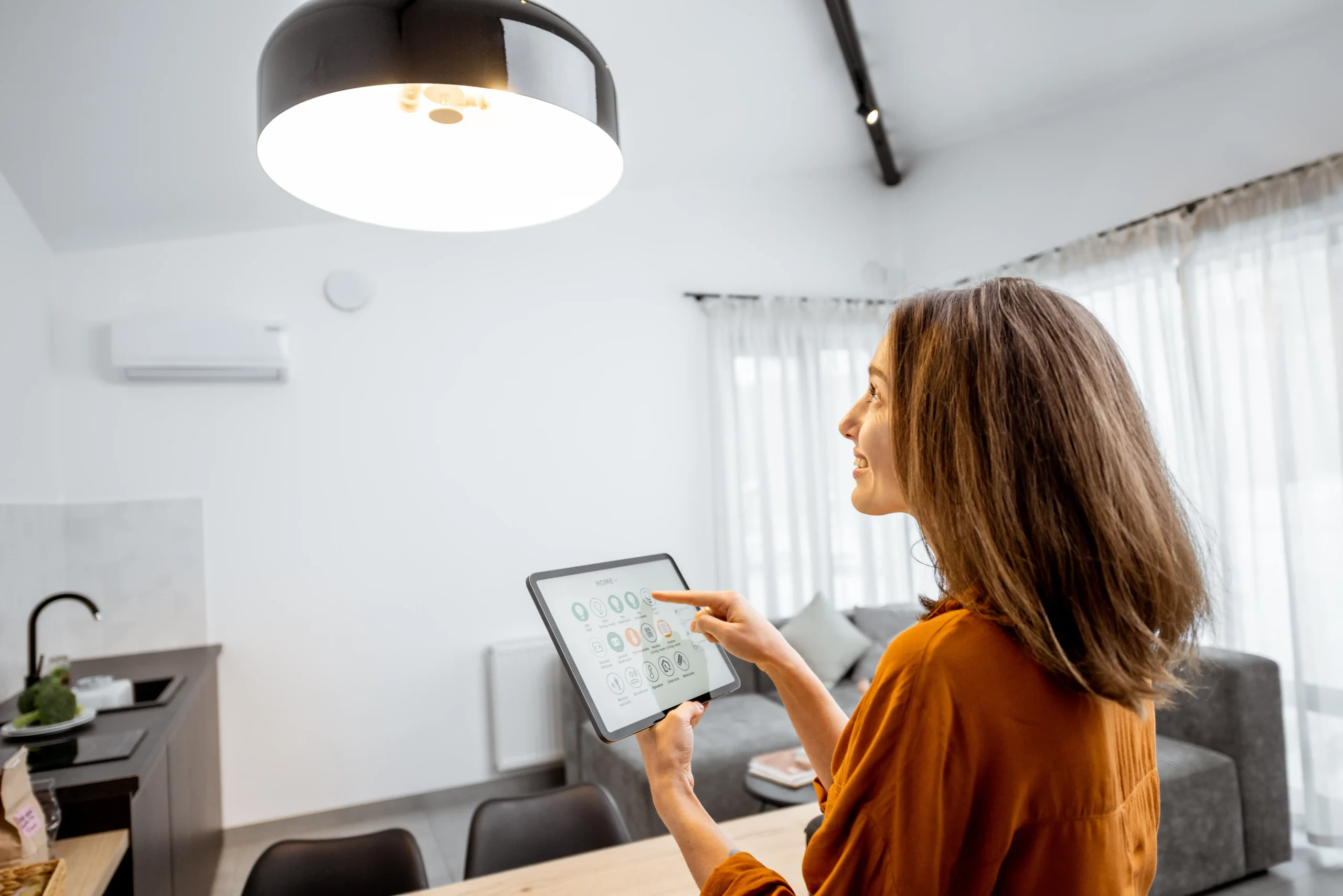 Woman using a tablet for smart home integration in a bright, modern kitchen