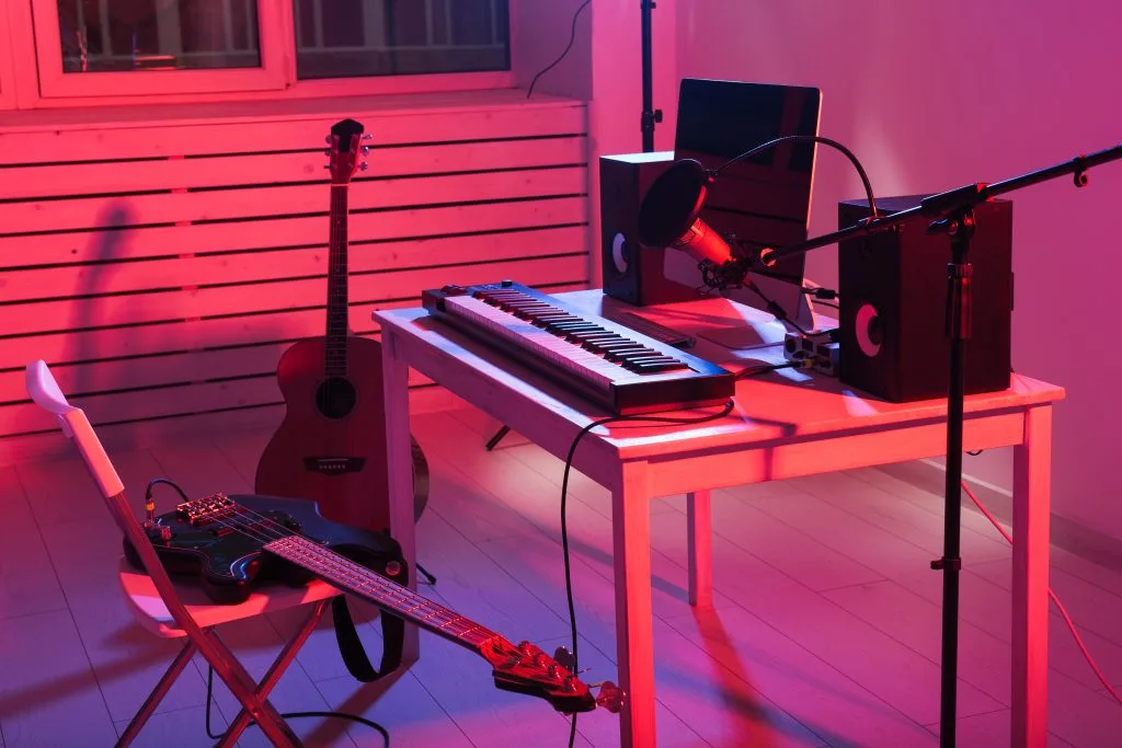 A music workspace features instruments and equipment illuminated by colorful lighting