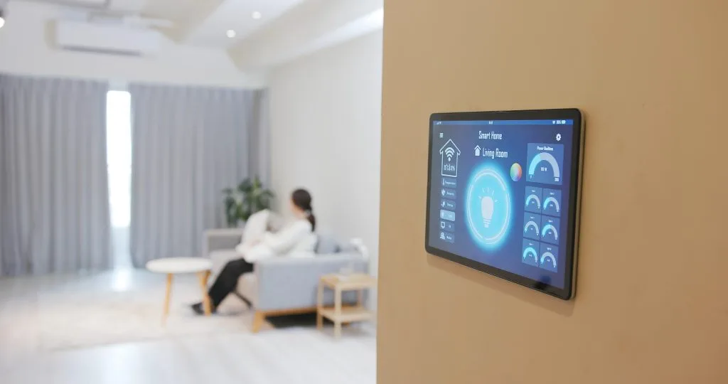 Exterior home lighting Winnipeg settings displayed on a digital control panel next to a woman on a couch