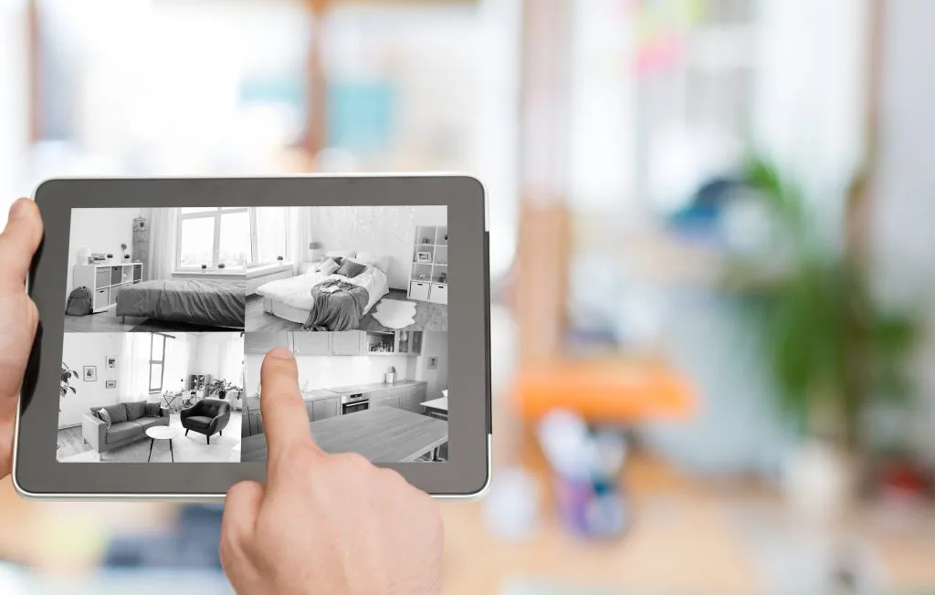A person uses a tablet to view multiple interior room designs