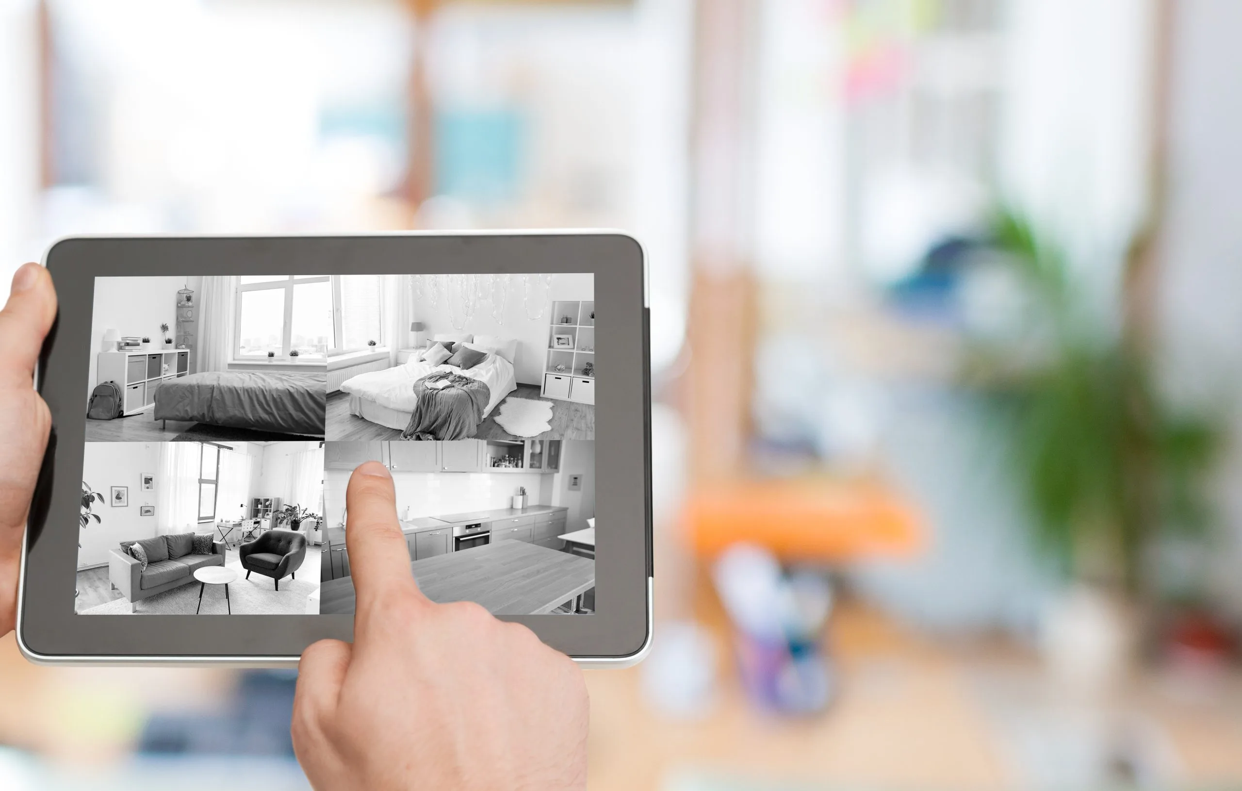 Person using a tablet to explore interior designs with alarm systems in Winnipeg