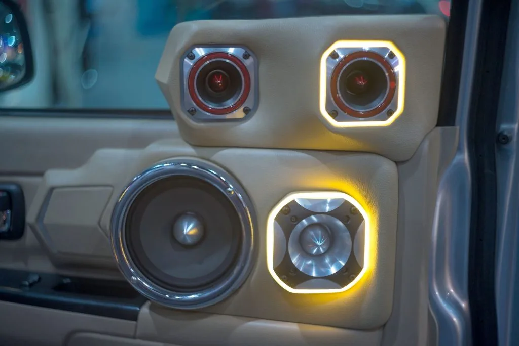 A car interior features stylish speakers with glowing accents