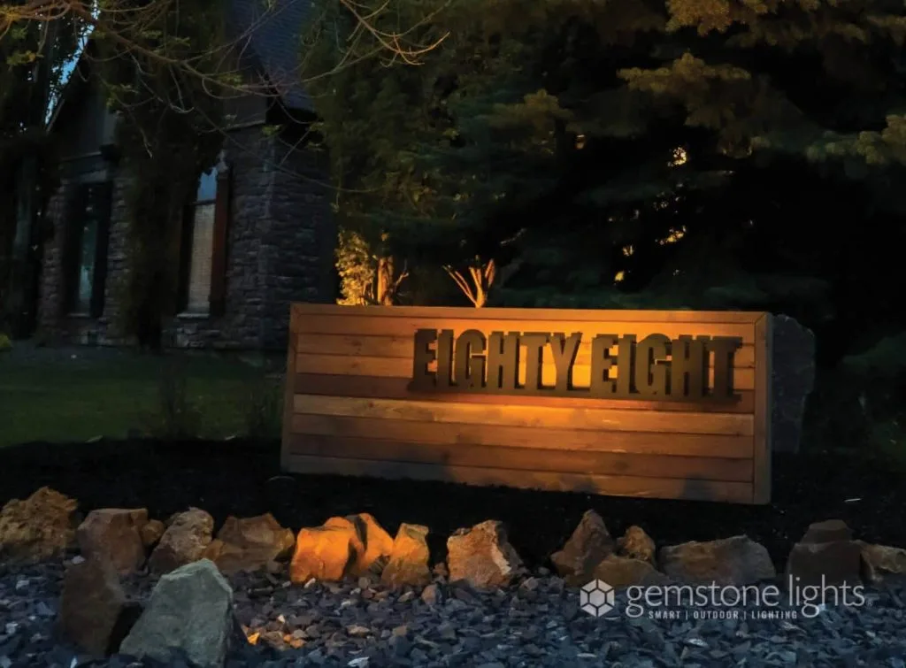 Illuminated wooden sign displays the number eighty-eight surrounded by decorative rocks
