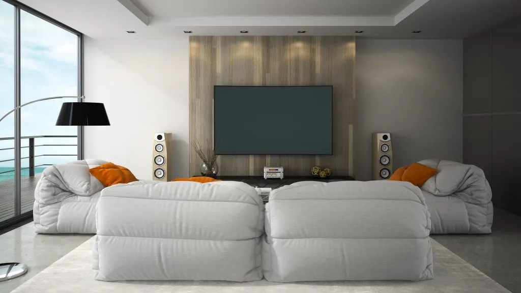A modern living room features cozy bean bag chairs and a large wall-mounted television